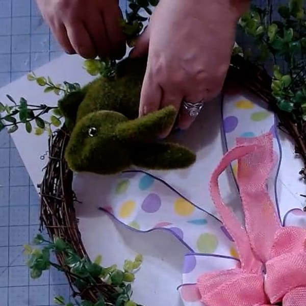 Adding more greenery to wreath