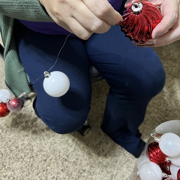 Threading ornaments onto wire.