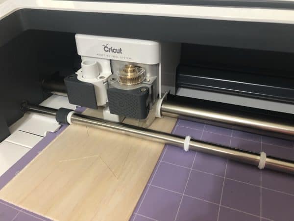 Cricut machine cutting a wooden star