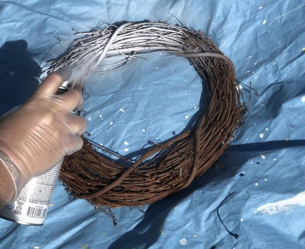Spray painting a wooden wreath
