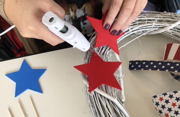 Gluing wooden stars to a grapevine wreath