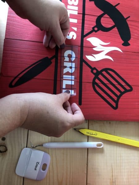 Vinyl graphic being applied to grill tools organizer